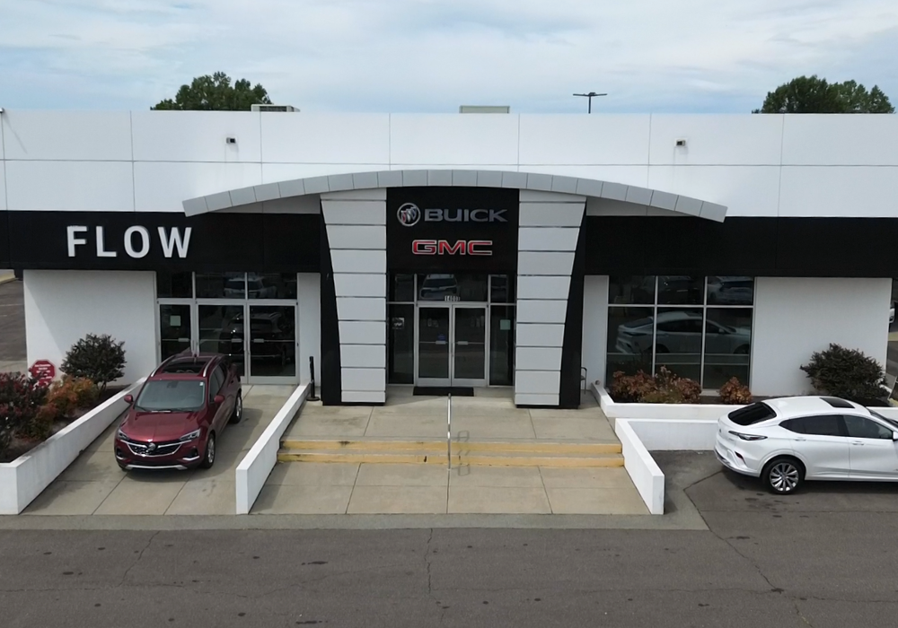Flow Buick GMC of Fayetteville dealership storefront with two cars parked in front